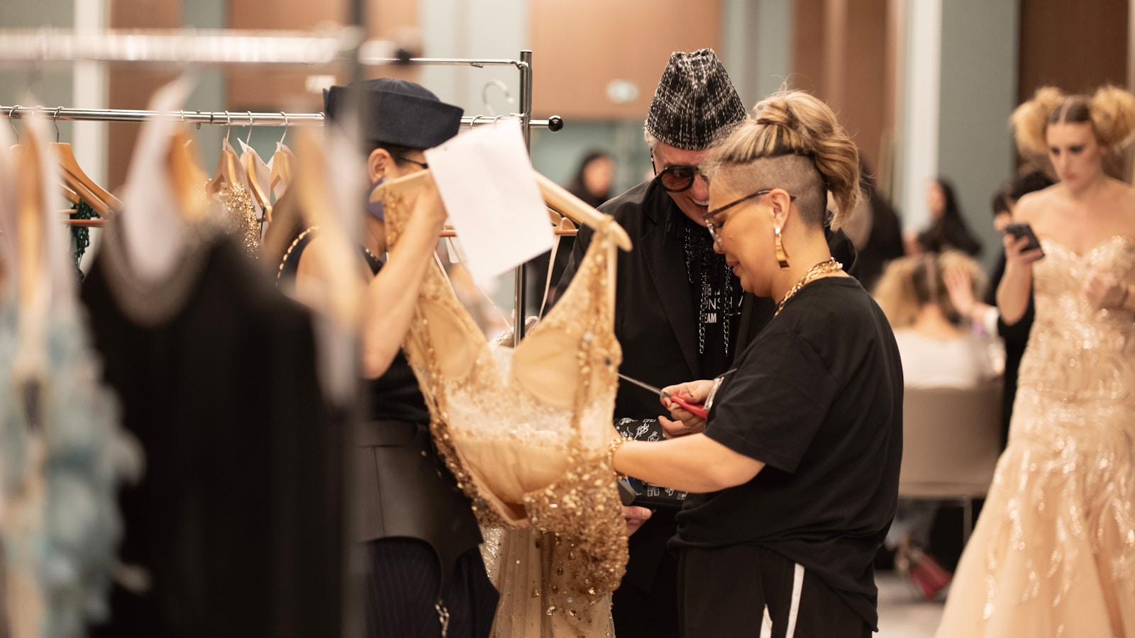 Designers are reviewing a dress in the backstage.