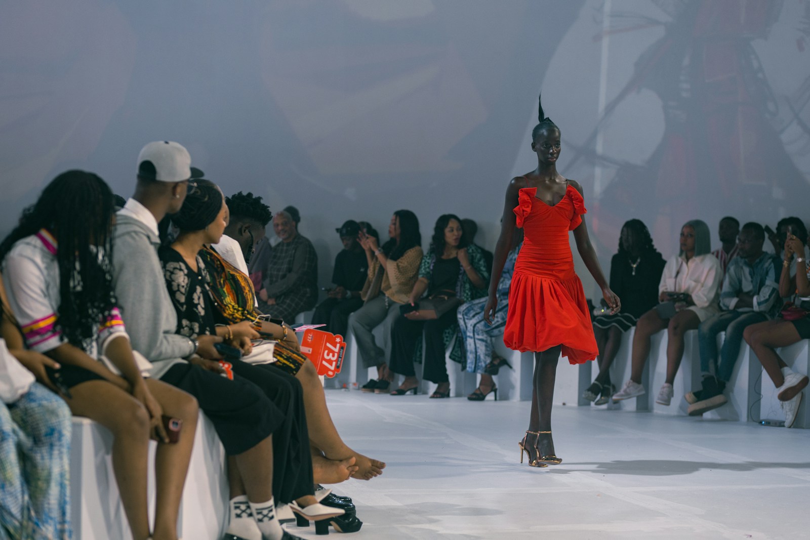 A woman in a red dress walking down a runway